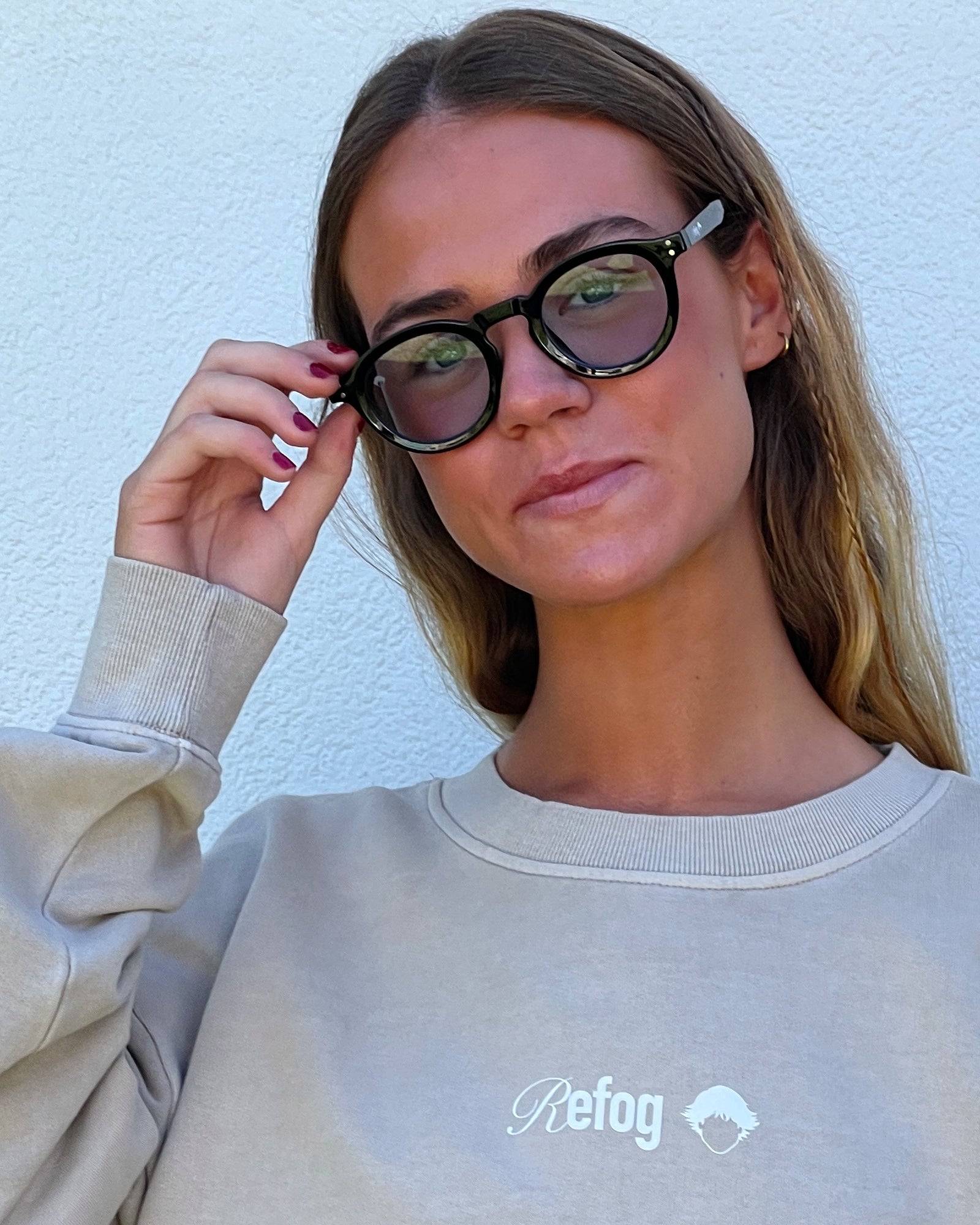 Gafas de sol Round Tardeo de Refog en look femenino con montura negra redonda y lentes azul claro.