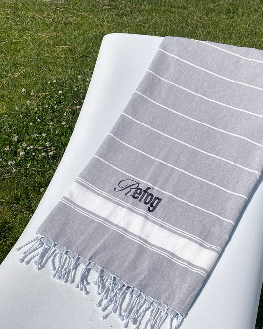 Toalla Refog en gris claro con texto serigrafiado